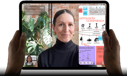 iPad Pro, parte frontal, posición horizontal, negro espacial, esquinas redondeadas, marco de la pantalla negro, manos sosteniendo los lados izquierdo y derecho, la pantalla muestra una conversación en FaceTime que se está traduciendo en vivo, y una app educativa que muestra una presentación sobre 