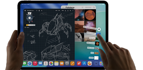 iPad Pro, negro espacial, una mano izquierda sostiene el dispositivo, una mano derecha apunta y hace un gesto para manipular varias ventanas de apps abiertas, una app de dibujo con bocetos de diseños mecánicos, fototeca con imágenes de planetas y del espacio, archivos de la carpeta de descargas desplegados en forma de abanico