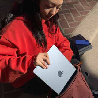 Una estudiante guardando una MacBook Air en su mochila