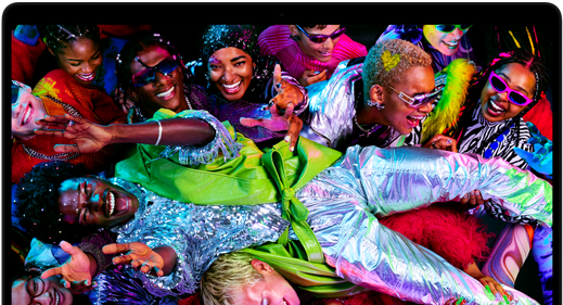 Imagen colorida de una persona en posición horizontal siendo sostenida por una multitud en una fiesta, destacando la brillante pantalla Liquid Retina XDR de la MacBook Pro