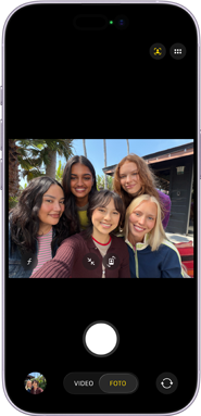 iPhone 17, frente, la pantalla muestra la cámara frontal Center Stage abierta con una selfie grupal de cinco personas centradas en el encuadre